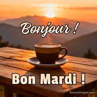 Tasse de café fumante sur une table en bois au lever du soleil, montagnes en fond, texte « Bonjour ! Bon mardi ! »