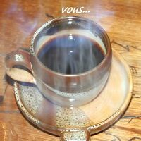 Une grande tasse de café fumant repose sur une table en bois, prête à être savourée.
